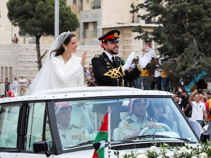 Rajwa Al Saif y el príncipe Hussein saludan durante su desfile por la calles de Amán tras su boda en el palacio de Zahran, este jueves.