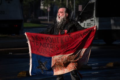 Un manifestante le grita a la policía durante la conmemoración del cuarto aniversario del estallido social en Santiago, este miércoles.