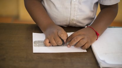 Un estudiante invidente lee mediante un sistema brailke adaptado.