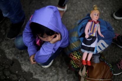 Una niña que vieja con sus padres, se sienta junto a su muñeca en la frontera de Agua Caliente con Guatemala, en su intento de unirse a la caravana de migrantes que se dirige a EE UU.