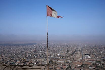 Una bandera peruana ondea desde el techo de un comedor de beneficencia local en el barrio de Villa María de Lima, Perú.