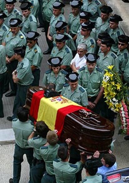 Guardias civiles conducen uno de los féretros al templo.