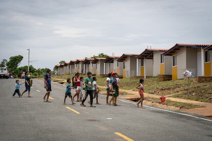 Una familia camina por una calle de Isber Yala. Las construcciones, 300 casas de PVC y cemento, han sido muy criticadas por algunos de los líderes guna, como Atilio Martínez: "Van a acabar con nuestras tradiciones".