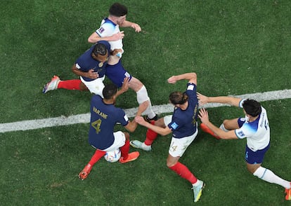 Jugadores ingleses y franceses pelean por un balón. 