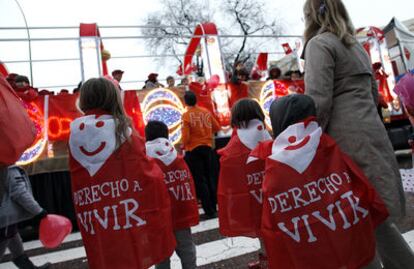 Varios niños con capaz de Derecho a Vivir al paso de la carroza, esta tarde en Chamartín.