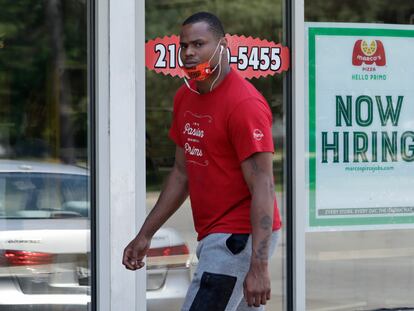 Un hombre pasa delante de un local de Marco's Pizza, que anuncia que está contratando personal en Euclid, Ohio.