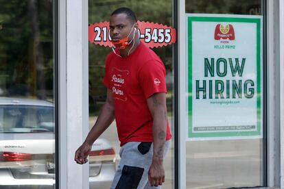 Un hombre pasa delante de un local de Marco's Pizza, que anuncia que está contratando personal en Euclid, Ohio.