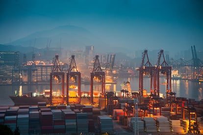 Vista de un puerto logístico con grúas de carga y contenedores.