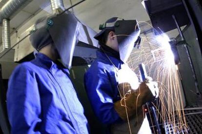 Dos alumnos en un taller de garantía social hacen ejercicios de fabricación mecánica en el instituto Juan de la Cierva, de Madrid.