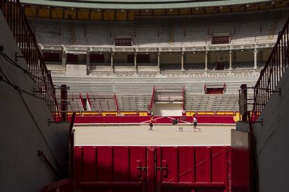 Varios jóvenes en el interior de la plaza de toros de Pamplona que permanece cerrada durante las fiestas de San Fermín, el 9 de julio.