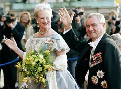 La reina Margarita de Dinamarca observa a su marido, el príncipe Henrik, saludar a los fotógrafos de prensa a su llegada al Palacio Real.