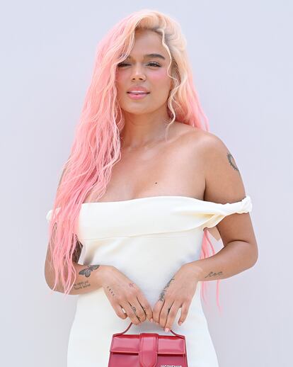 Karol G acudió al desfile de Jacquemus en Versalles el pasado 26 de junio y posó para los fotógrafos luciendo una imponente melena rosa que destacaba sobre su vestido blanco.