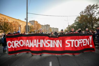 Protesto do movimento Querdenken, que se opõe às medidas de contenção do coronavírus, em 7 de novembro, na cidade de Leipzig. Na bandeira, lê-se "Parem com a loucura do coronavírus".