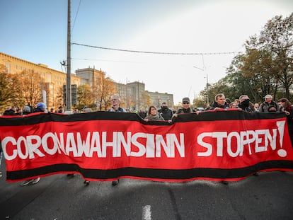 Protesto do movimento Querdenken, que se opõe às medidas de contenção do coronavírus, em 7 de novembro, na cidade de Leipzig. Na bandeira, lê-se "Parem com a loucura do coronavírus".