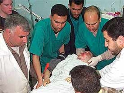 El cadáver de la pacifista es trasladado por varios médicos palestinos.