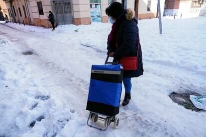 Una mujer regresa a casa tras hacer la compra días después del Temporal Filomena