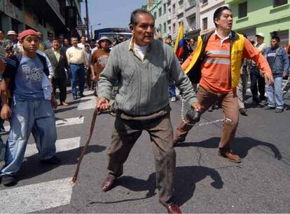 Unos manifestantes se enfrentan a la policía fuera del Parlamento en Quito.