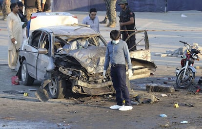 Oficiales de seguridad inspeccionan los daños materiales en el escenario de un atentado suicida que causó al menos 25 muertos y más de 40 heridos, en Lahore, Pakistán.