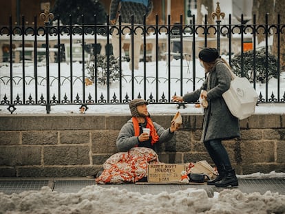 Un hombre sin hogar recibe un donativo en la ciudad de Nueva York, Estados Unidos, en diciembre de 2020.