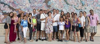 El pintor Emilio Pérez (en el centro, con pantalones azules y camisa blanca) posa junto a su familia cubana frente a 'Un verso sencillo' durante la 12 Bienal de La Habana.