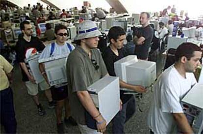 Participantes en el Campus Party recogen sus ordenadores para volver a casa.