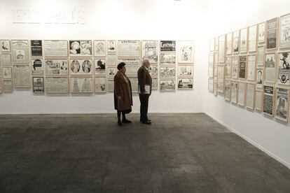 Dos personas observan un conjunto de obras del artista Fernando Bryce presentes en el stand de El País instalado en la feria Arco.