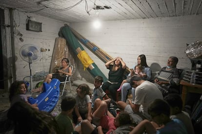 Varias personas se refugian ante las sirenas antiaéreas que advierten de ataques iraníes, este martes en Bnei Brak (Israel).