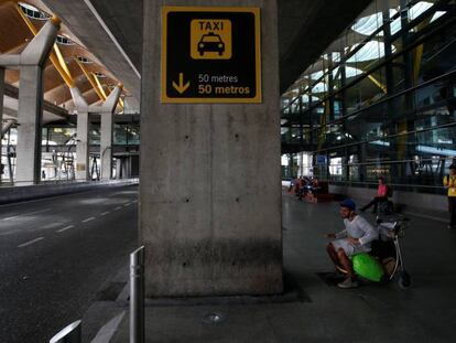 Un hombre espera sentado frente a la fila de taxis de la T4 de Madrid, vacía durante el pasado martes por la huelga de estos profesionales.