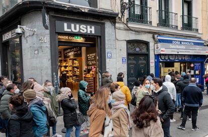 Varias personas hacen cola en la administración de lotería 'Doña Manolita', en Madrid.