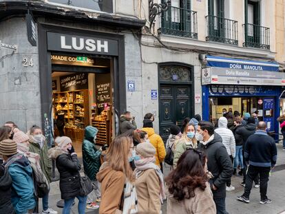 Varias personas hacen cola en la administración de lotería 'Doña Manolita', en Madrid.