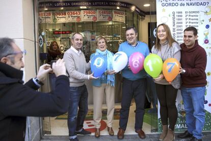 Los empleados de la administración de loteria que ha repartido el cuarto premio con el número 07617, posan con los números premiados en globos, en la capital vizcaina durante el tradicional sorteo navideño.