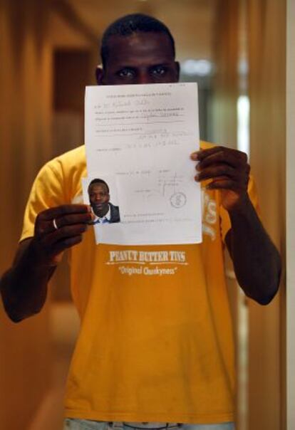 El hermano de Seydou muestra algunos documentos.