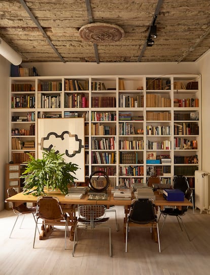 La biblioteca está surtida por igual de libros heredados, novedades editoriales y un gran chillida. Delante, una mesa diseñada por Albistur y rodeada de sillas de Perriand. Las sillas de rejilla metálica las compraron al Centro Pompidou cuando el museo fue reformado.