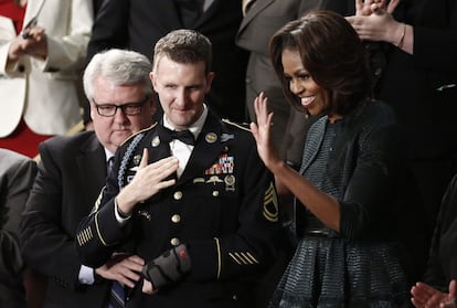 El sargento estadounidense Cory Remsburg (c) y la primera dama Michelle Obama (d) escuchan al presidente Barack Obama pronunciar su discurso anual sobre el Estado de la Unión.