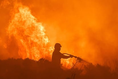 Un bombero intenta apagar las llamas del incendio, este lunes cerca de Ávila.
