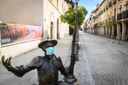 Estatua de Don Quijote con una mascarilla frente a la Casa Natal de Miguel de Cervantes en Alcalá de Henares.