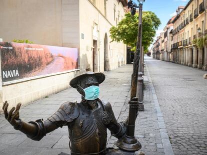 Estatua de Don Quijote con una mascarilla frente a la Casa Natal de Miguel de Cervantes en Alcalá de Henares.