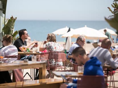 Turistas en una terraza junta al mar en la Barceloneta (Barcelona).