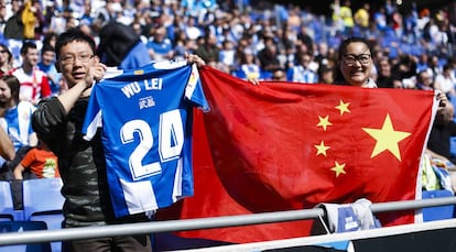 Aficionados chinos con la bandera de su país y una camiseta de Wu Lei en Cornellà.