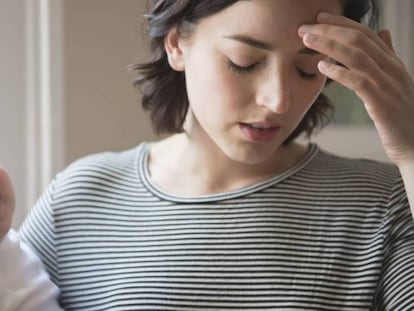 Una madre agotada con su bebé llorando.