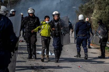 La policía antidisturbios detiene a un migrante durante los enfrentamientos cerca del campo de refugiados y migrantes de Moria, en la isla de Lesbos (Grecia).