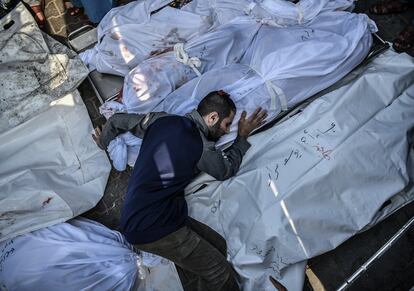 A Palestinian watches over the bodies of his relatives at Nasser hospital in Gaza.