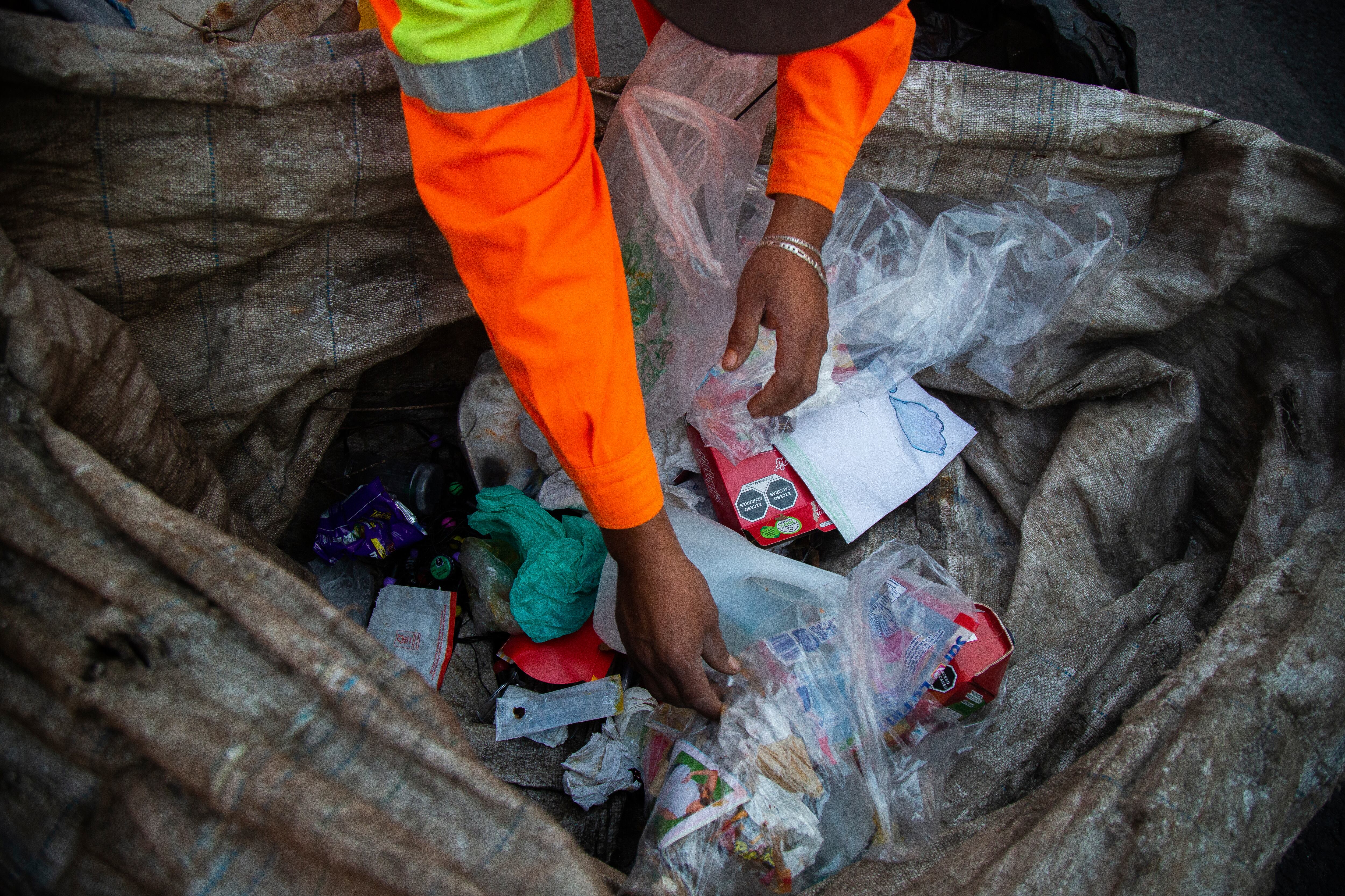 Cruz selecciona algunos objetos entre la basura.