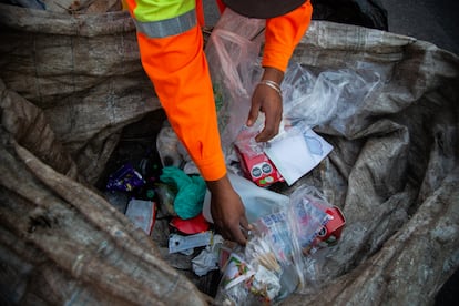 Cruz selecciona algunos objetos entre la basura.