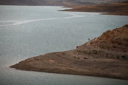 Un hombre pesca en el pantano de La Viñuela.