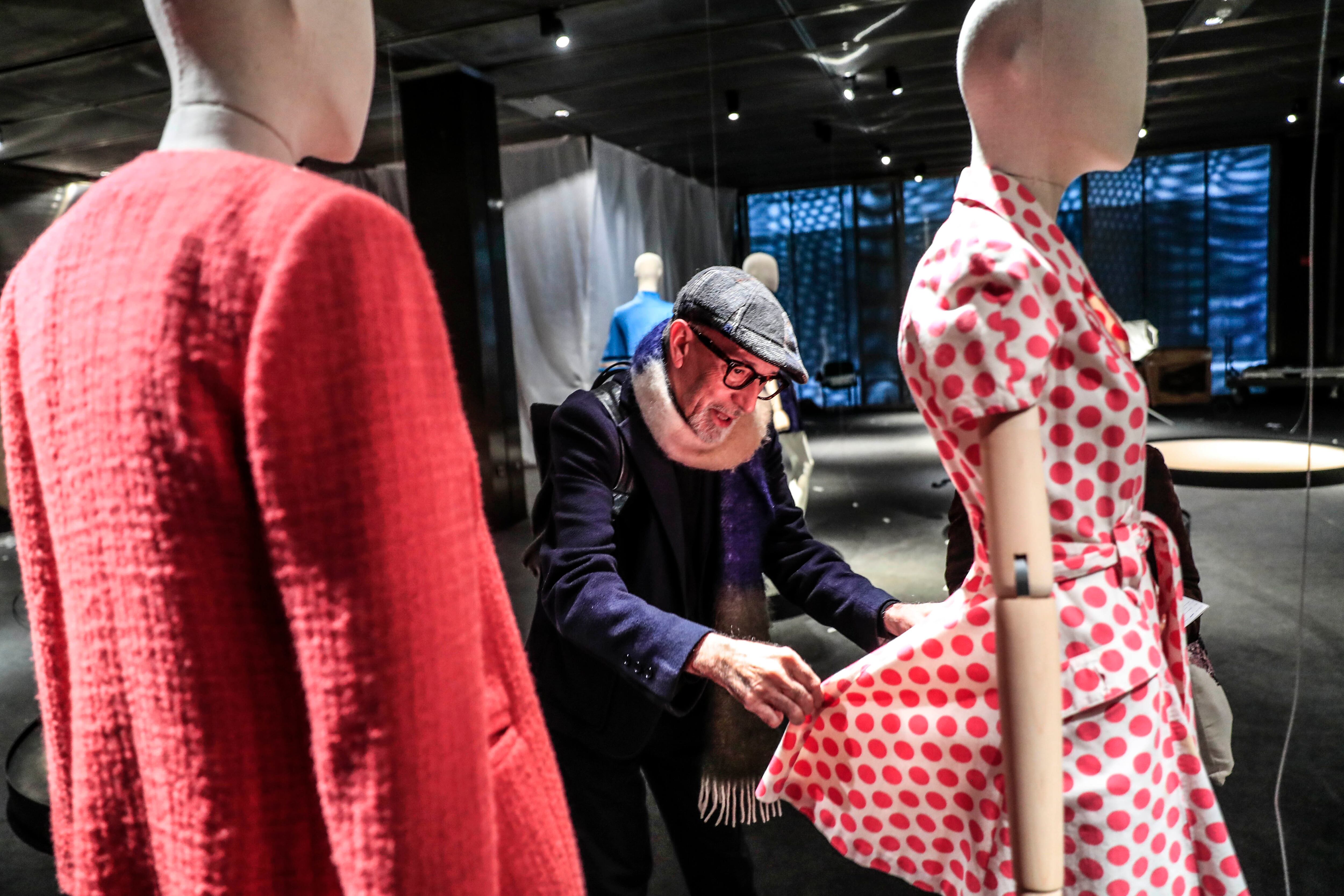 Antonio Alvarado junto a dos propuestas de la exposición, un vestido camisero del que destaca sus patrones y un traje que él denomina 