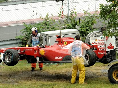 Los operarios retiran de la pista el coche de Fernando Alonso tras su accidente en el Gran Premio de Canadá.