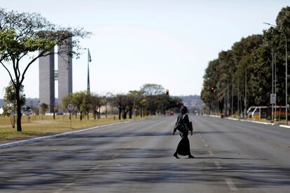 Una mujer camina por la Explanada de los Ministerios completamente vacía en Brasilia.