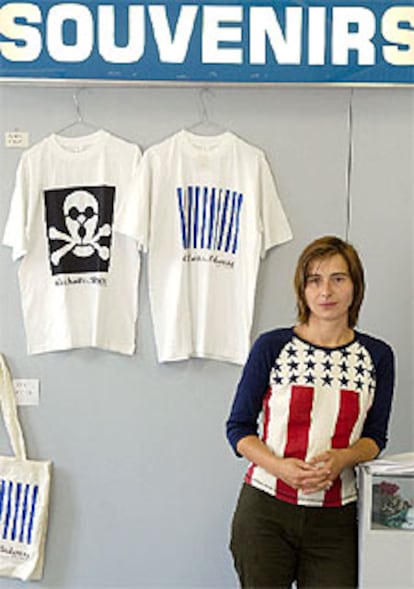 La artista Agata Siwek posa junto a camisas con sus diseños sobre Auschwitz.