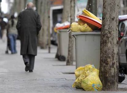 Un contenedor de basura repleto de bolsas, en una calle del centro de Madrid.